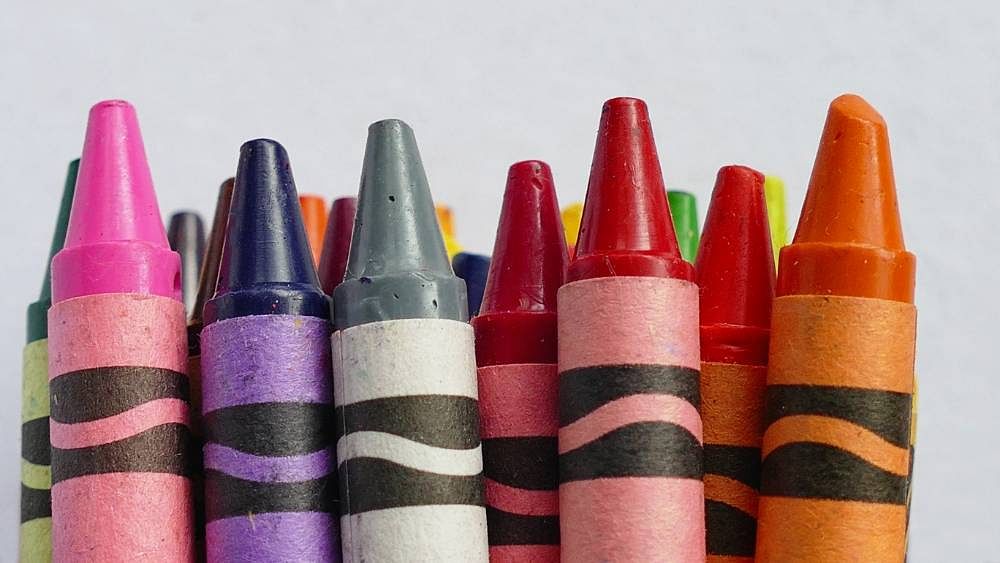 An variety of different colored Crayola Crayons lined up in a row for a beginner magic trick