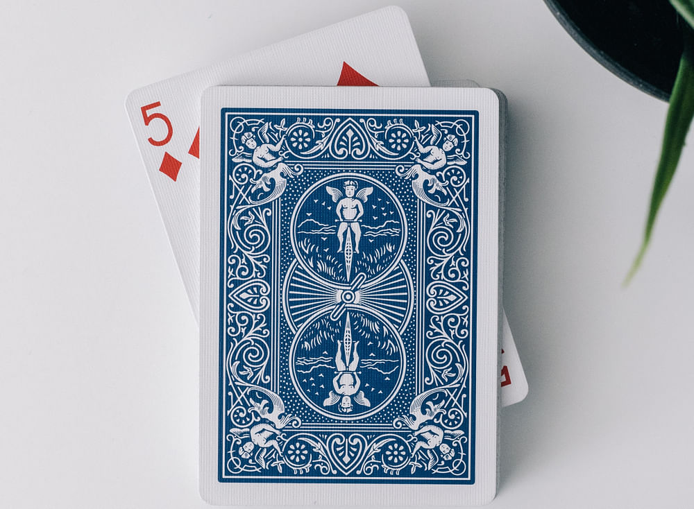 blue bicycle playing cards and a face up 5 of diamonds playing card