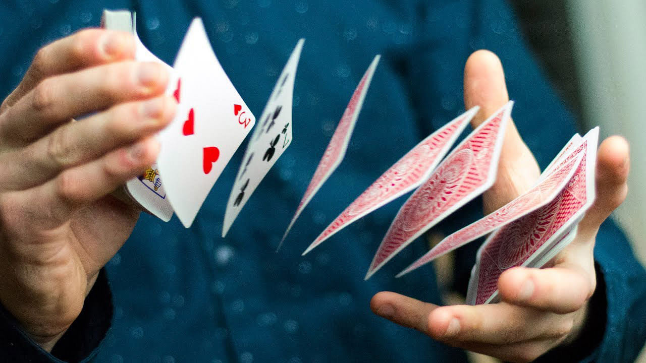 magician springs cards between hands with card spring flourish