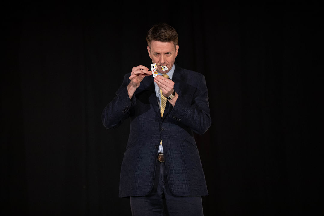 English Magician Guy Hollingworth performs an amazing card trick on stage at the Magifest magic convention