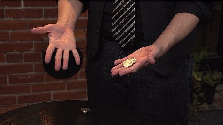 magician performs coin magic with half dollar coins