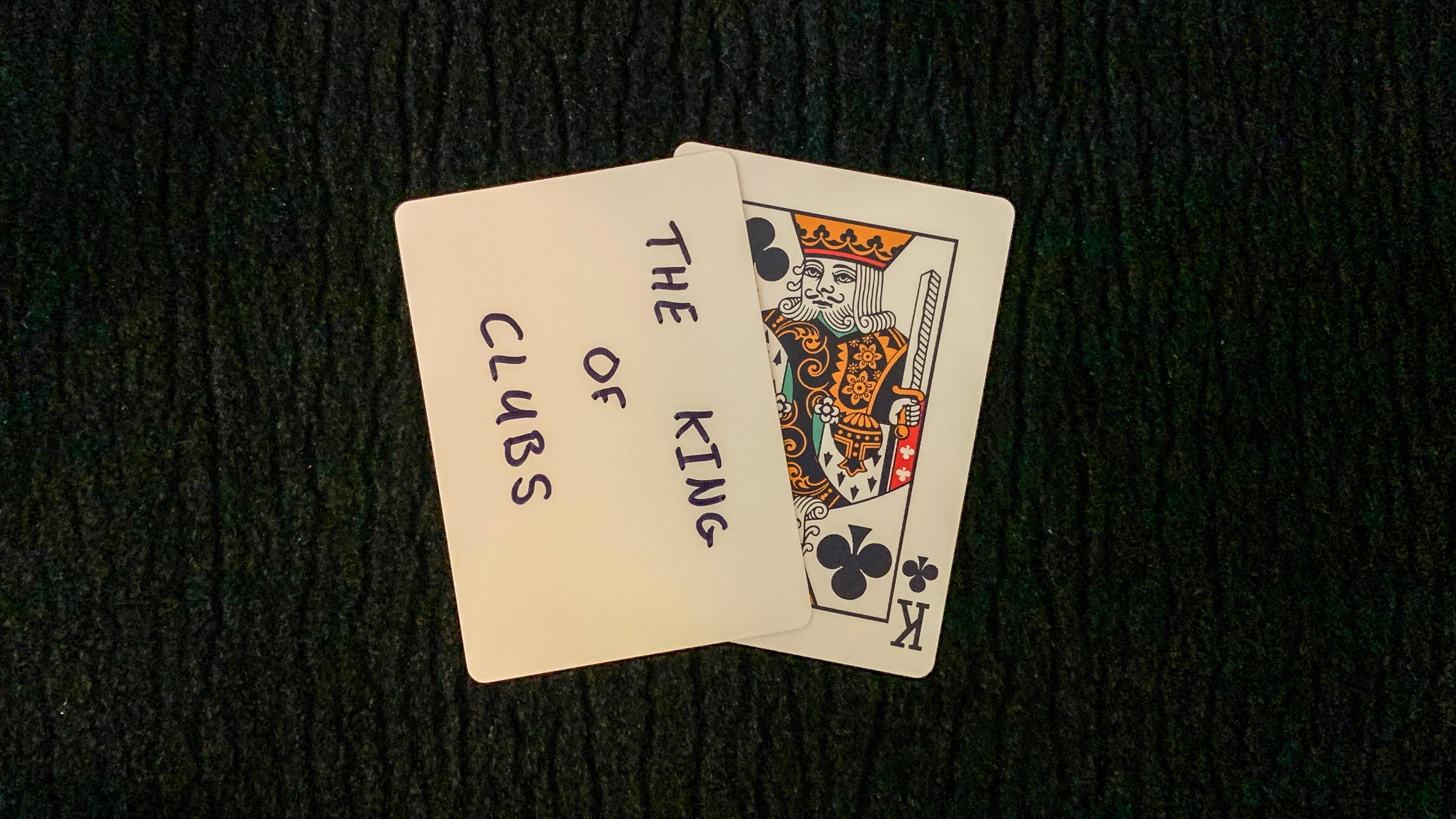 King of Clubs is written on the face of a blank playing card used in a card trick