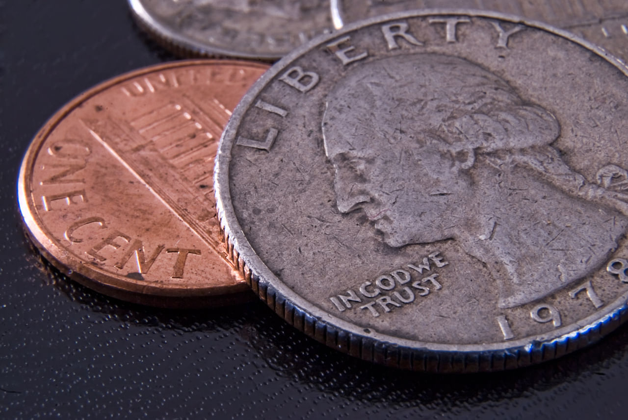 close up shot of a quarter and penny used in a coin magic trick for beginners