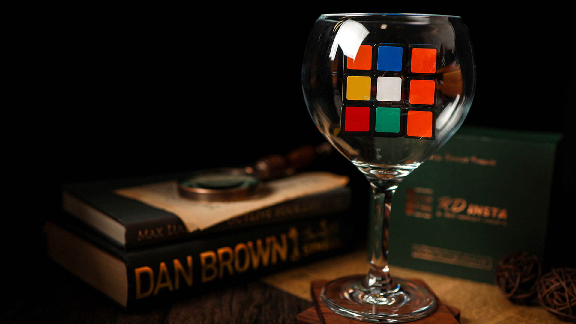 unsolved rubik's cube sits in a wine glass on a table