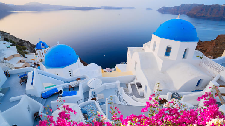 Panoramic view of Santorini with white buildings and blue domes against the Aegean Sea